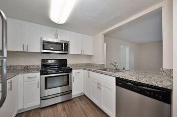A kitchen with white cabinets and stainless steel appliances.